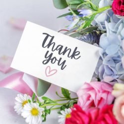 Thank you card on blossom flower bouquet and pink ribbons
